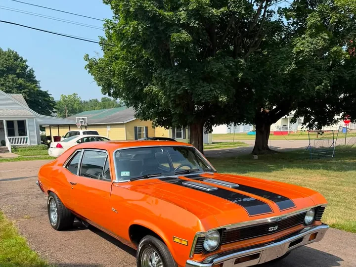 Orange Chevrolet Nova parked outdoors.