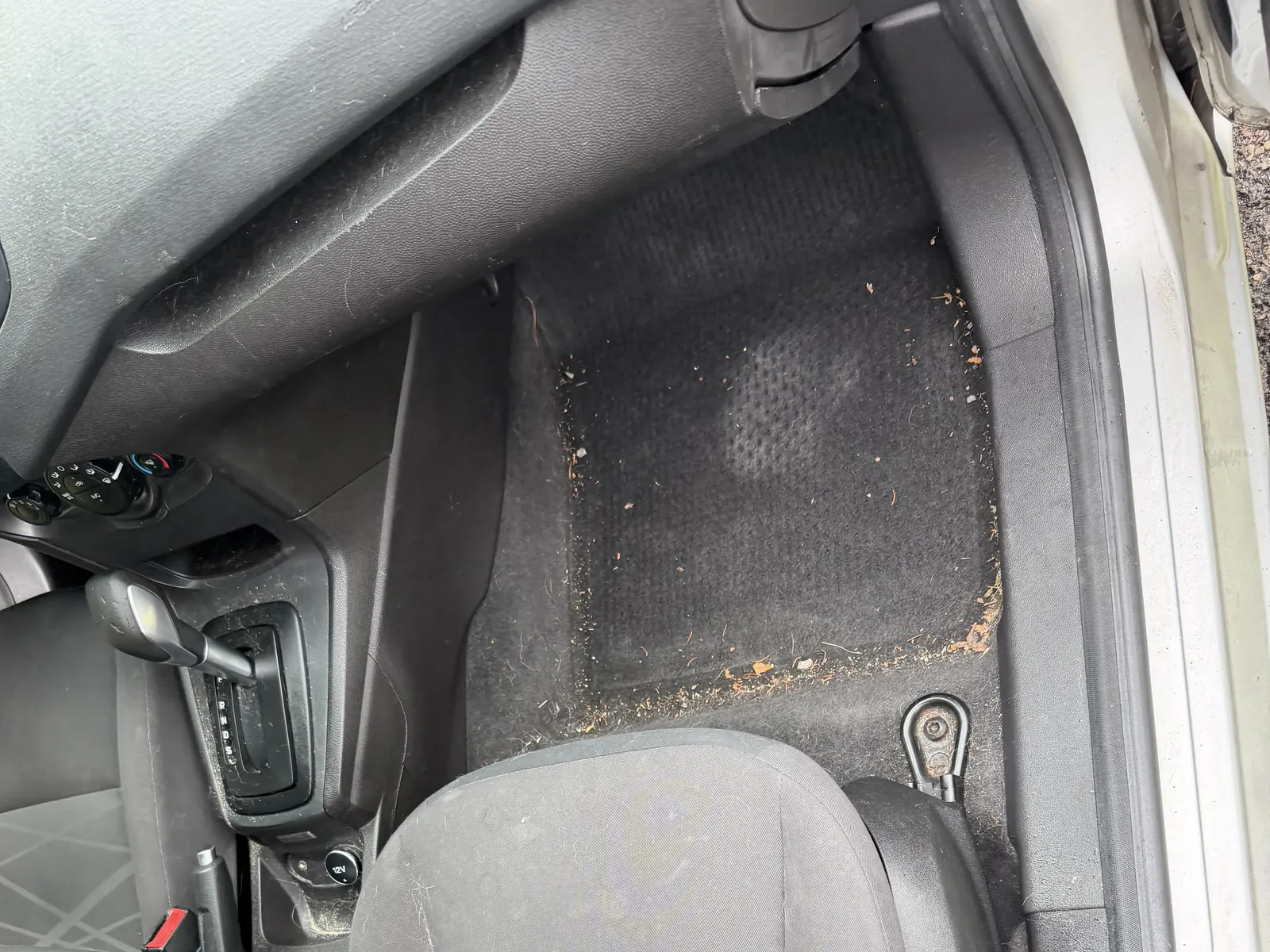 Ford front passenger area before interior detailing, with debris visible on the floor.